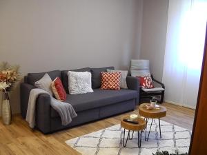 a living room with a blue couch and a chair at Appartamento ARCOBALENO in Tirano