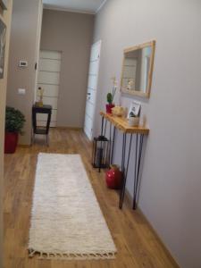 a hallway with a table and a mirror and a rug at Appartamento ARCOBALENO in Tirano