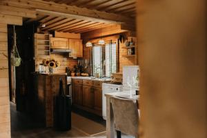 a kitchen with wooden cabinets and a white appliances at Cosy and romantic forest house in Putten