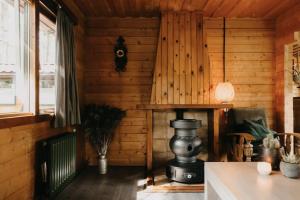a room with a wooden wall with a stove at Cosy and romantic forest house in Putten