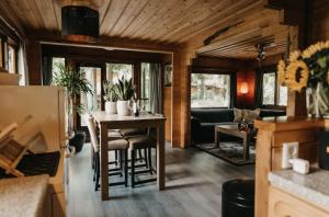 a kitchen and living room with a table and chairs at Cosy and romantic forest house in Putten