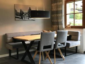 uma sala de jantar com uma mesa de madeira e cadeiras em Haus Sieben Zwerge em Ehrwald