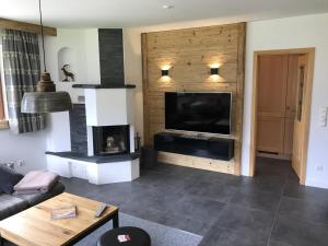 a living room with a fireplace and a flat screen tv at Haus Sieben Zwerge in Ehrwald