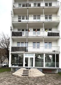 ein hohes weißes Gebäude mit Fenstern und Balkonen in der Unterkunft SUNSET Apartment AirCon - Self Check-In 24h in Breslau