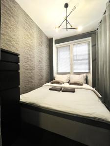 Schlafzimmer mit einem großen Bett und einem Fenster in der Unterkunft SUNSET Apartment AirCon - Self Check-In 24h in Breslau