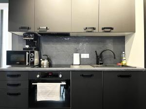 a kitchen with a stove and a sink and a microwave at SUNSET Apartment - Self Check-In 24h in Wrocław