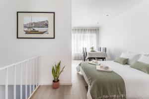 um quarto branco com uma cama e uma mesa em Casa Trindade no Porto