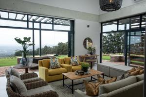 a living room with couches and tables and windows at Taaibosch Collection in Stellenbosch +45 photos