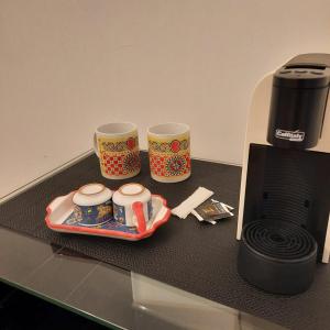dos tazas de café y una bandeja en una mesa junto a una impresora en Quattrocantiapartments, en Palermo