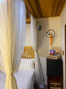 Pousada Village Mel في إيلها دو ميل: غرفة نوم بسرير مع مظلة بيضاء