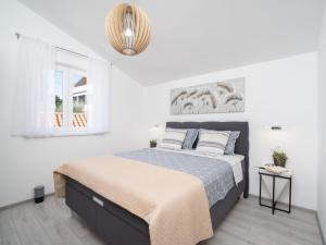 een witte slaapkamer met een bed en een raam bij Apartment Gaia in Labin