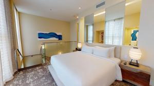 Un dormitorio con una gran cama blanca y una lámpara en Eden Roc Miami Beach, en Miami Beach