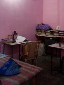 une chambre avec deux bureaux, une table et des chaises dans l'établissement Laxmi boys Hostel By WB Inn, à Kanpur