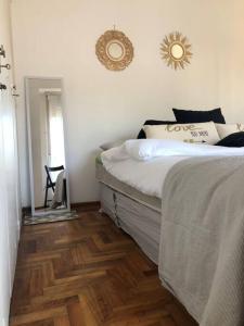 een slaapkamer met een bed en een houten vloer bij Departamento En Vicente Lopez in Vicente López