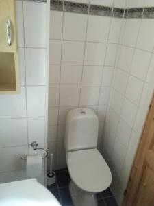 uma casa de banho com WC e uma parede de azulejos brancos em Björktorpet em Linneryd