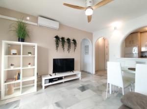 uma sala de estar com uma televisão de ecrã plano e uma mesa em Laguna Beach Paradise - Alojamientos La Torre em Torrox Costa