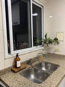 encimera de cocina con fregadero y ventana en Depto confortable en calle Bicentenario en Salta