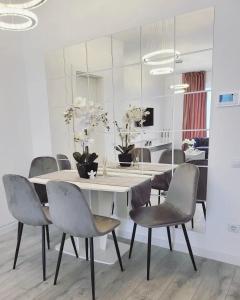 uma sala de jantar com uma mesa branca e cadeiras em Apartament Antonia em Sibiu