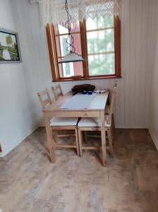uma mesa de madeira e cadeiras numa sala de jantar em Björktorpet em Linneryd
