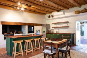 uma cozinha com uma ilha verde e uma mesa em Taaibosch Collection em Stellenbosch