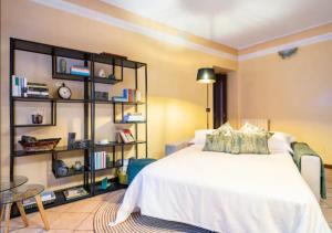 1 dormitorio con cama blanca y estante para libros en LAGO D'ISEO - Ampio alloggio in centro storico en Pisogne