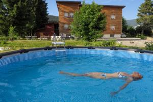 zwei Personen schwimmen im Pool in der Unterkunft Gîte CROCUS - 2 personnes - "Les Gites du Chalet" à Autrans in Autrans