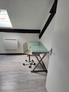 einen Schreibtisch und einen Stuhl in einem Zimmer in der Unterkunft L'ancre de la Seille in Château-Salins