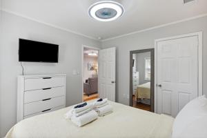 a white bedroom with a bed and a flat screen tv at 207 W Cooper Coral Cassita Central Location in Folly Beach