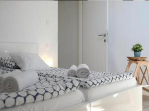 Una cama blanca con toallas encima. en Apartments Blue Lavender en Cres