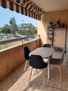 uma varanda com uma mesa e cadeiras e uma janela em Appartement 3P avec garage proche aéroport, tramway et avec toutes commodités! em Nice