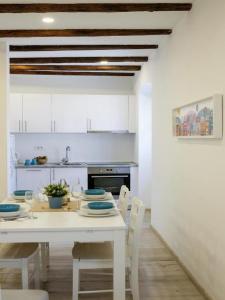 a white kitchen with a white table and chairs at Apartments Blue Lavender in Cres