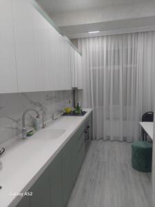 uma cozinha com armários brancos e um balcão branco em Luxury Guest House em Sumqayıt