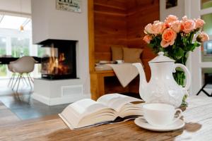 een vaas met bloemen en een boek en een kop koffie bij Seaside Lodge Sylt in Westerland
