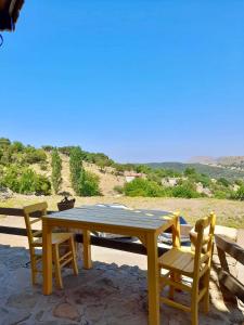 een gele tafel en stoelen op een patio bij SARI KEÇİ TAŞ OTEL in Gokceada Town