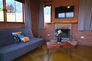 a living room with a couch and a fireplace at Recanto da Paineira - Pedra da Balança in São Bento do Sapucaí