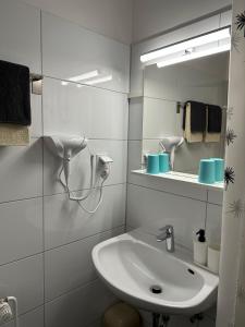 a white bathroom with a sink and a mirror at Hotel Uthoff in Bissendorf