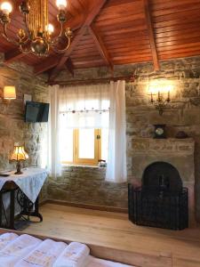 a living room with a stone fireplace and a table at SARI KEÇİ TAŞ OTEL in Gokceada Town