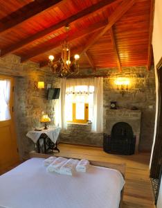 een slaapkamer met een bed en een open haard bij SARI KEÇİ TAŞ OTEL in Gokceada Town