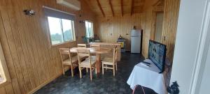 kuchnia ze stołem, krzesłami i lodówką w obiekcie Agroturismo los Colihues 2 w mieście Castro