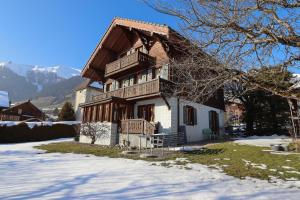 a house in the snow with mountains in the background at Valrose in Chateau-d'Oex