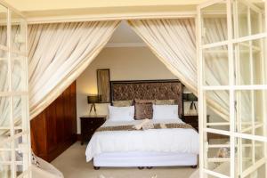 a bedroom with a large white bed and two bunk beds at TDM's Boutique Guest House in Pretoria