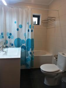 a bathroom with a toilet and a shower curtain at PIX Apartments in Madalena
