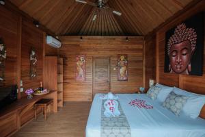 - une chambre avec un grand lit dans une pièce dotée de murs en bois dans l'établissement Villa Felise, à anur