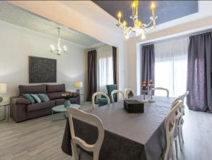 a dining room and living room with a table and chairs at Near FCB STADIUM. One car free parking. in Barcelona