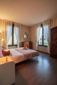 um quarto com uma cama, janelas e um candeeiro em Maison 6ch, vue sublime & parc arboré em Charleville-Mézières