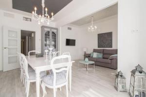a dining room and living room with a white table and chairs at Near FCB STADIUM. One car free parking. in Barcelona