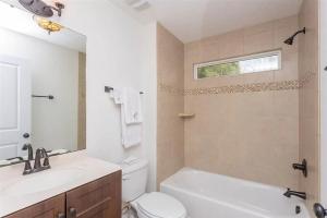 a bathroom with a toilet and a tub and a sink at Modern, Upscale, and New Blue Bungalow in the heart of Downtown St Augustine in Saint Augustine