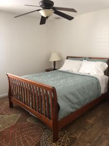 a bedroom with a bed with a ceiling fan at Modern, Upscale, and New Blue Bungalow in the heart of Downtown St Augustine in Saint Augustine