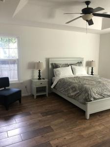 a bedroom with a bed and a ceiling fan at Modern, Upscale, and New Blue Bungalow in the heart of Downtown St Augustine in St. Augustine
