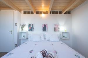 sypialnia z dużym białym łóżkiem z białymi poduszkami w obiekcie Porta Galliera Apartment w Bolonii